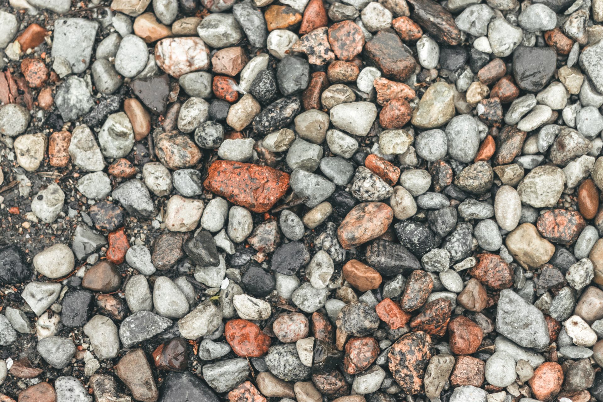 Das Bild zeigt eine Fläche mit vielleicht handgroßen Steinen unterschiedlicher Farbe. Durch die große Menge wirken sie wie eine einzelne Masse, und kein Stein sticht hervor. Sinnbildlich für die große Masse an Influencer, die im Endeffekt doch alle gleich sind.
